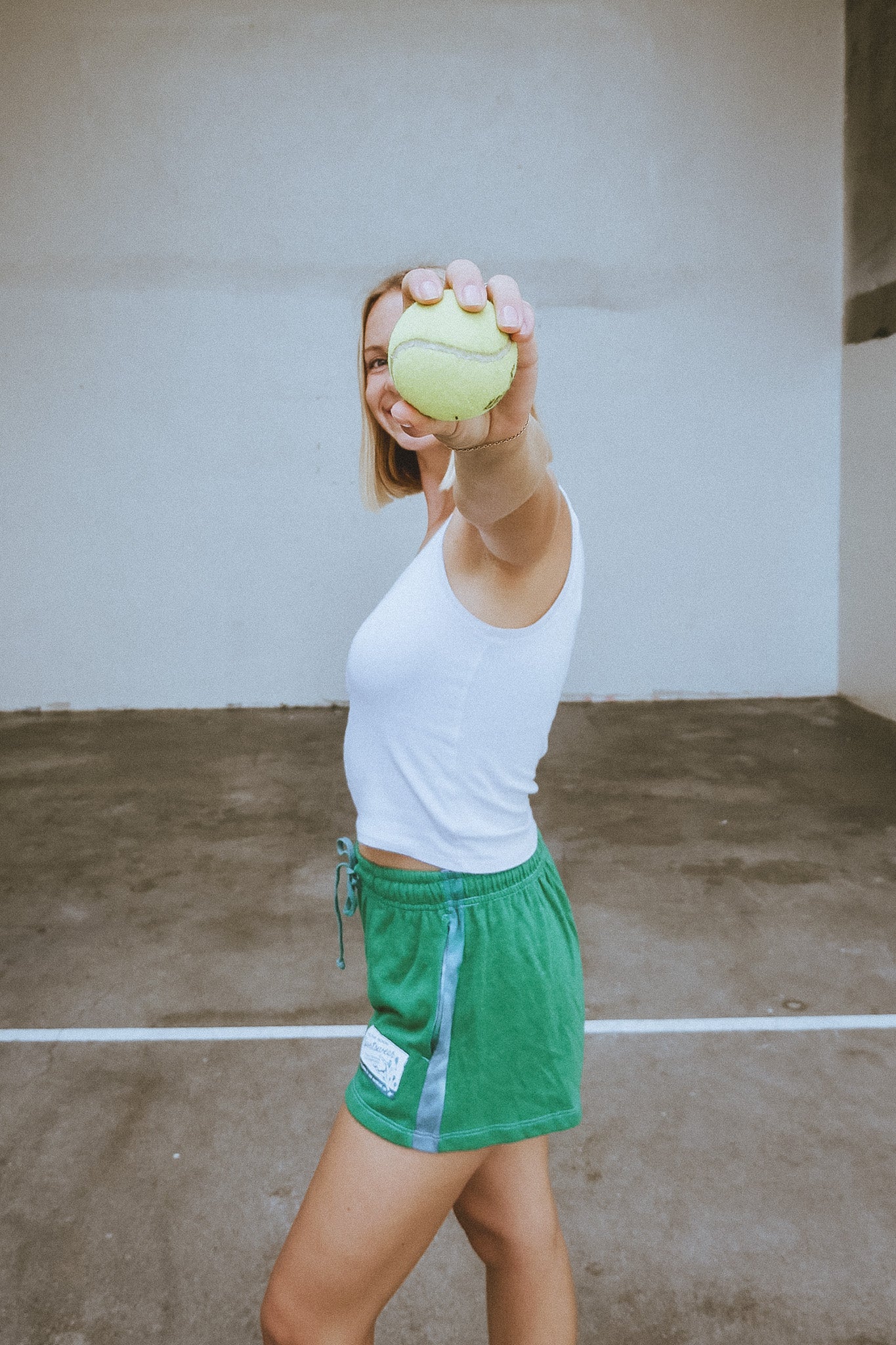 Person holding a tennis ball in an outdoor setting