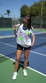 Person on a tennis court holding a racket
