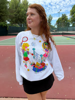 Person wearing a colorful sweatshirt with graphics on a tennis court