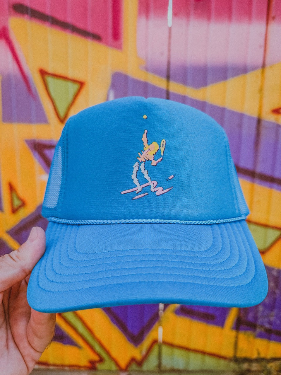  blue tennis trucker hat with a classic tennis player design by ace the moon tennis apparel company
