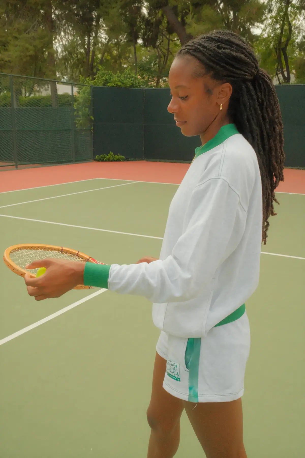Person on a tennis court holding a racket and ball