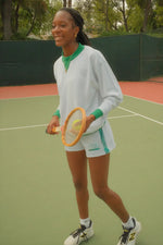 Person holding a tennis racket on a tennis court