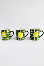 Three mugs with tennis ball design on a white background