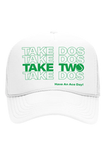 White cap with green text 'Take Dos Two Have An Ace Day!' on a white background