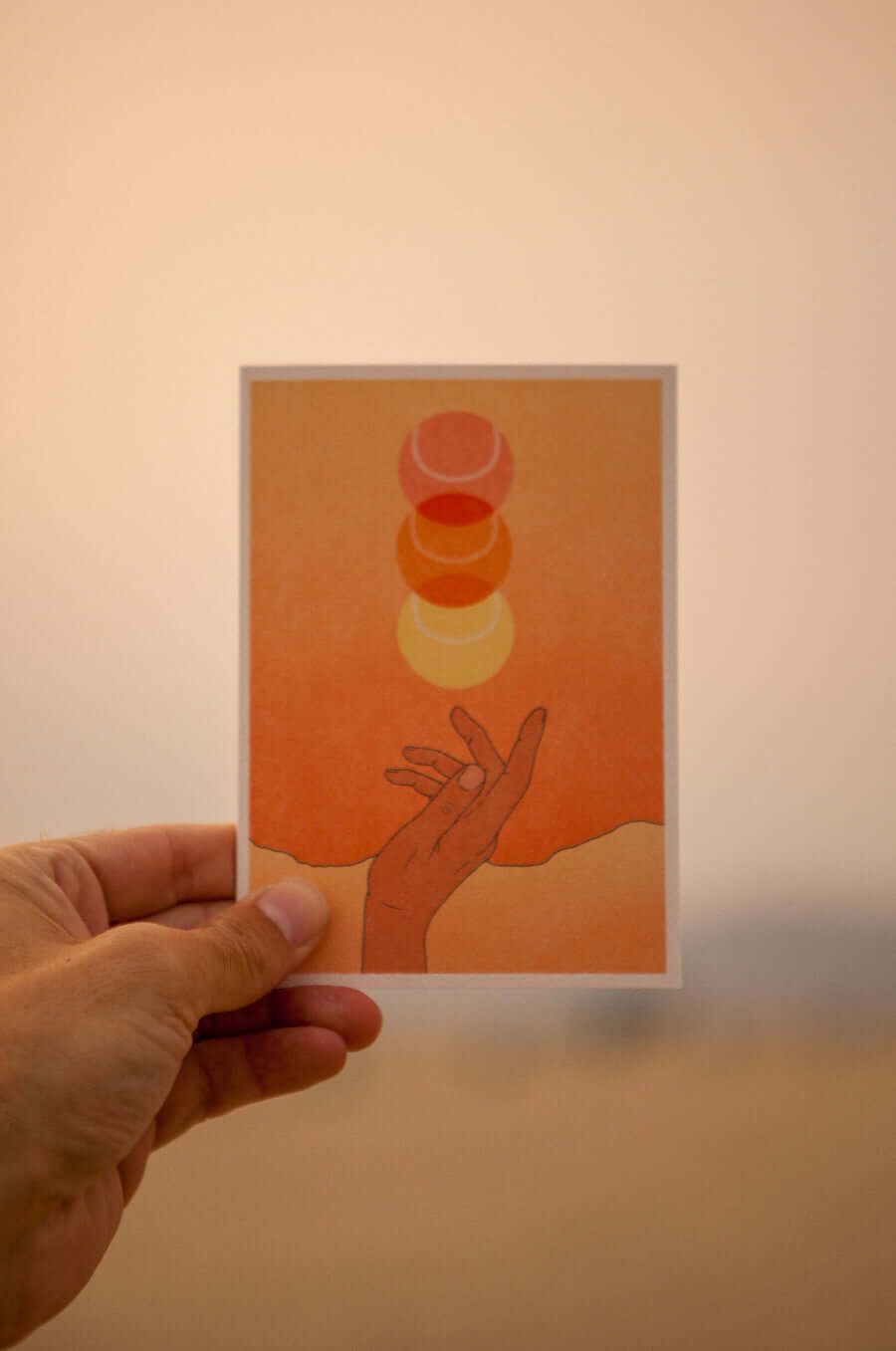 beautiful stationary card in sunburst orange sunset boho colors showcasing a hand throwing up a tennis ball that looks like a sunset. card by Ace the Moon premium tennis brand