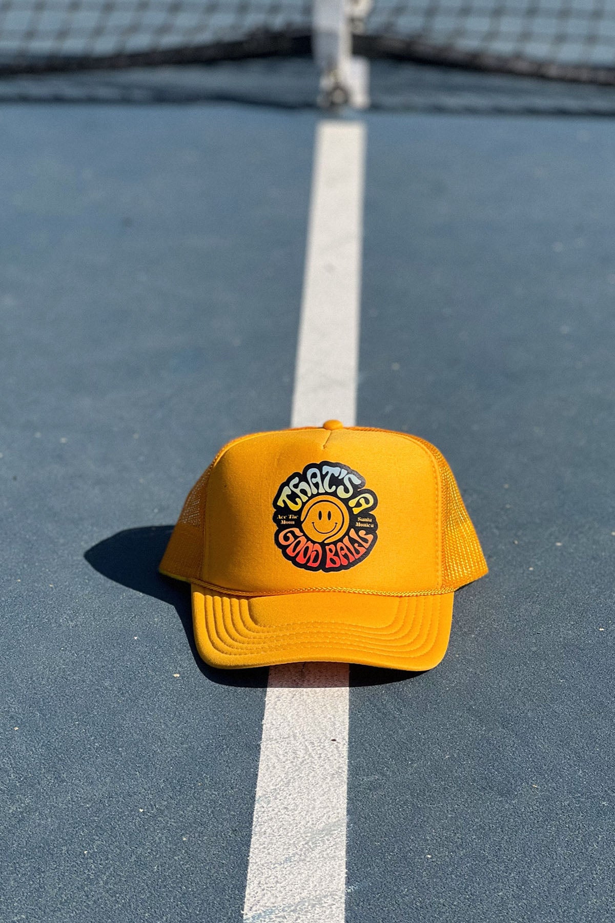 That's A Good Ball Tennis trucker hat in yellow by Ace the Moon LA tennis apparel brand. 