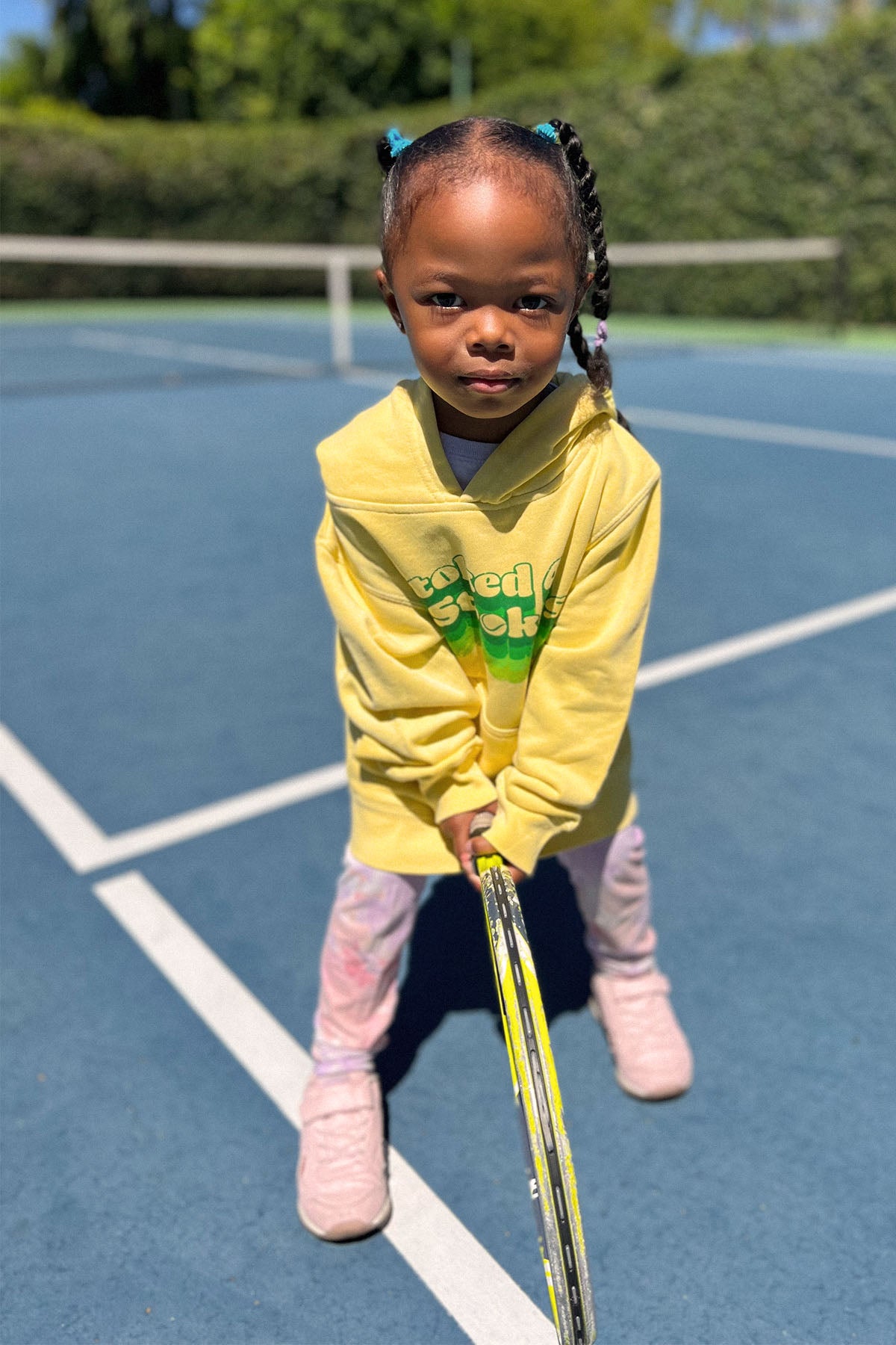 stoked 4 strokes kids hoodie in yellow worn by adorable kid holding a  tennis racket. sweatshirt made by Ace the Moon LA premium tennis apparel brand