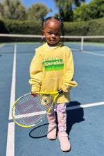 stoked 4 strokes kids hoodie in yellow worn by adorable kid holding a  tennis racket. sweatshirt made by Ace the Moon LA premium tennis apparel brand